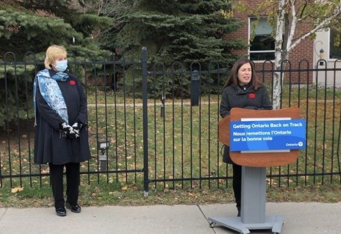 Laurie Scott stands with staff of the Ross Memorial Hospital near a podium